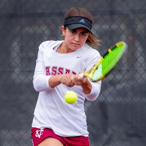 Pictured: Macey Dowd ’25 - Woman hitting a two-handed backhand on a tennis court.