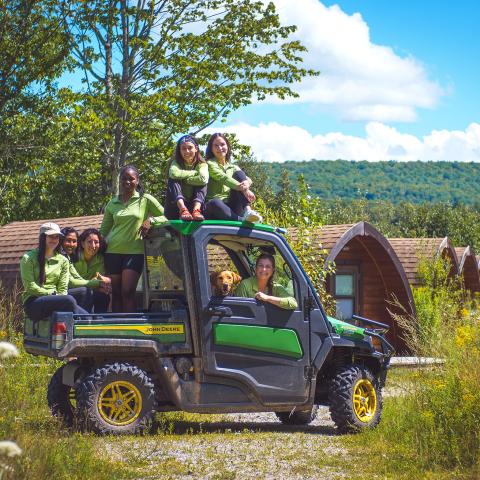 Group of students sitting on and in an off-road pickup truck