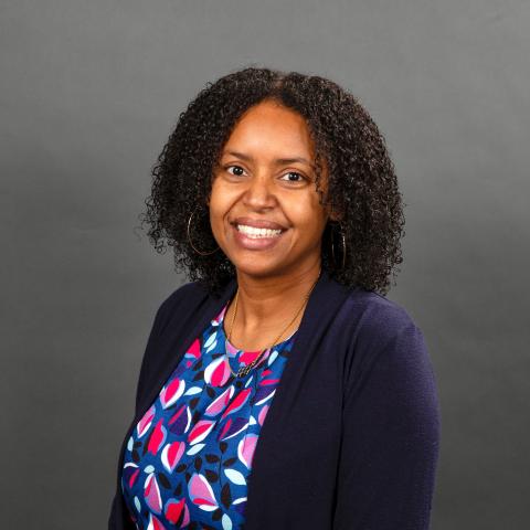 Woman with a blue petal pattern shirt and blue blazer smiling - Pictured: Krystle McLaughlin