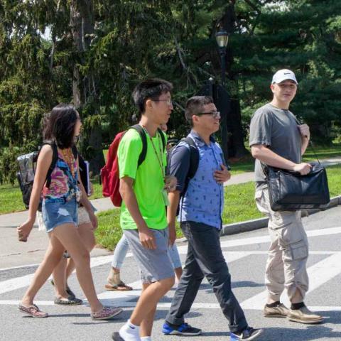 Group of people crossing a road on Vassar Campus on a sunny summer day