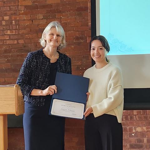 President Bradley and a student receiving an award certificate