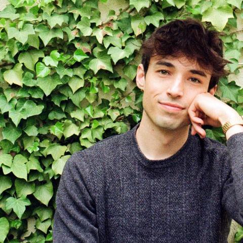 Will Dwyer poses in front of an ivy wall.