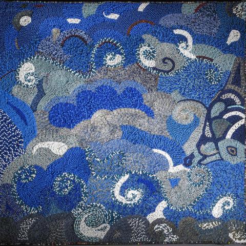 Beadwork of overlapping blue and silver cloud-like forms.