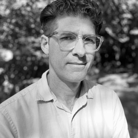 A black and white photo of Richard Ocejo, a person with short dark hair and glasses.