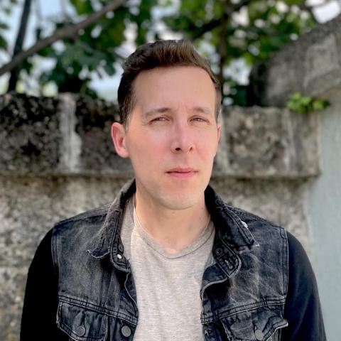 A portrait of Drake Andersen, a person with short brown hair and a dark denim jacket.