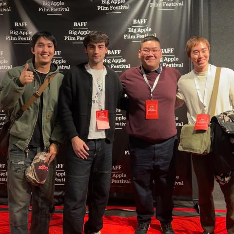 Four people standing on the red carpet in front of a drop banner with logos that read "BAFF: Big Apple Film Festival".