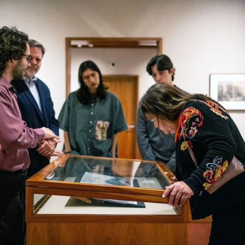 People in a museum gallery looking into a glass case.