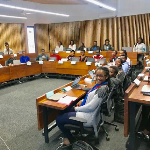 UGHE students sitting at desks positioned in a “U” shape in a classroom.